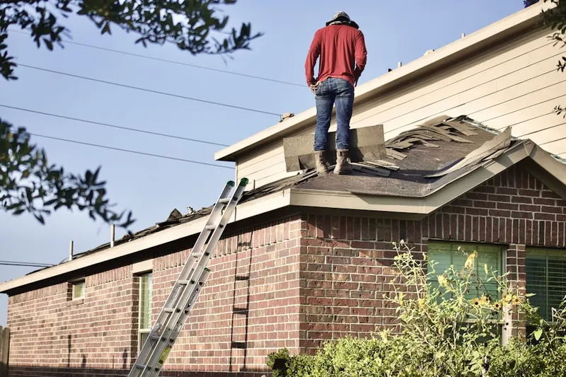 Professional roofer working on a residential roof in Maple